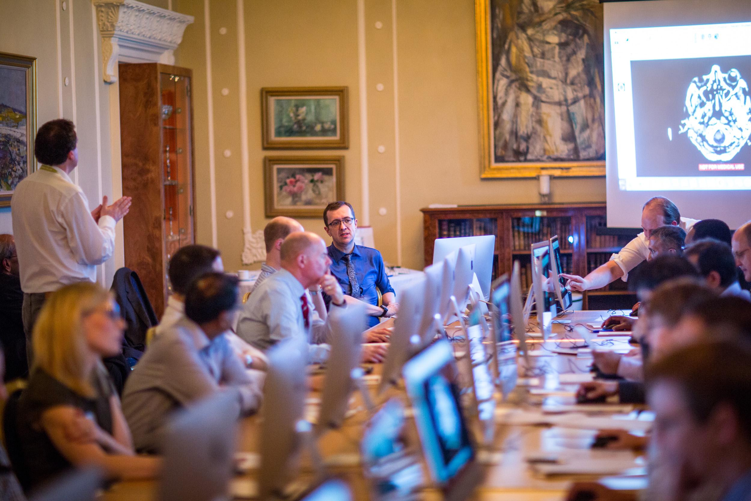 Staff members gathered round a table for a meeting at the College