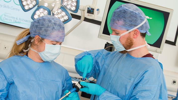A group of surgeons looking at equipment in a surgical theatre