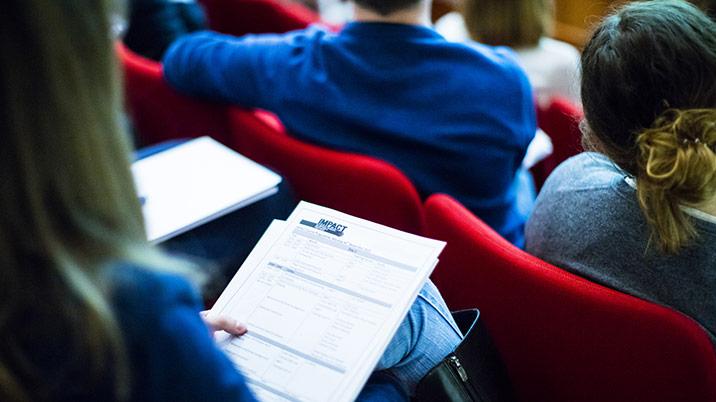 A person in a lecture hall with notes