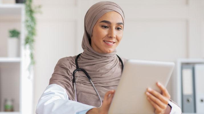 A person with a stethoscope and a tablet
