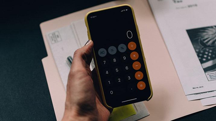 Person holding phone with calculator app showing